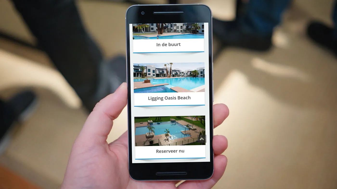 Een smartphone in de hand met de mobiele site en de knop om te reserveren